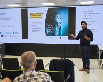 Roy Saurabh giving the invited lecture at CITIC, Universidade da Coruña, in front of a slide titled Integrating federated learning with data governance